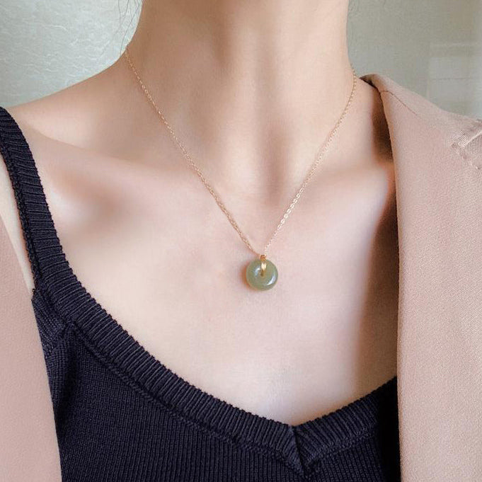 Necklace with a green pendant worn by a person